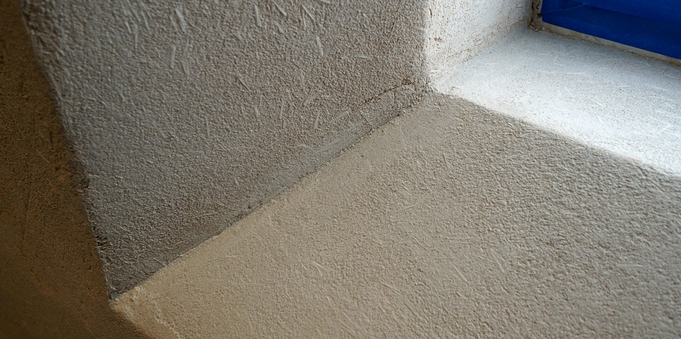 Hand troweled concrete scratch coat on wall